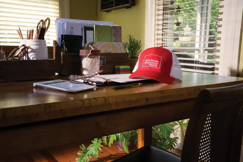 Farm Bureau Insurance of Tennessee red hat sitting on desk in home office