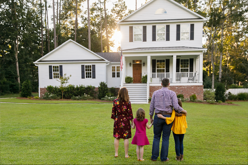 Family standing outside of their new home that they just purchased