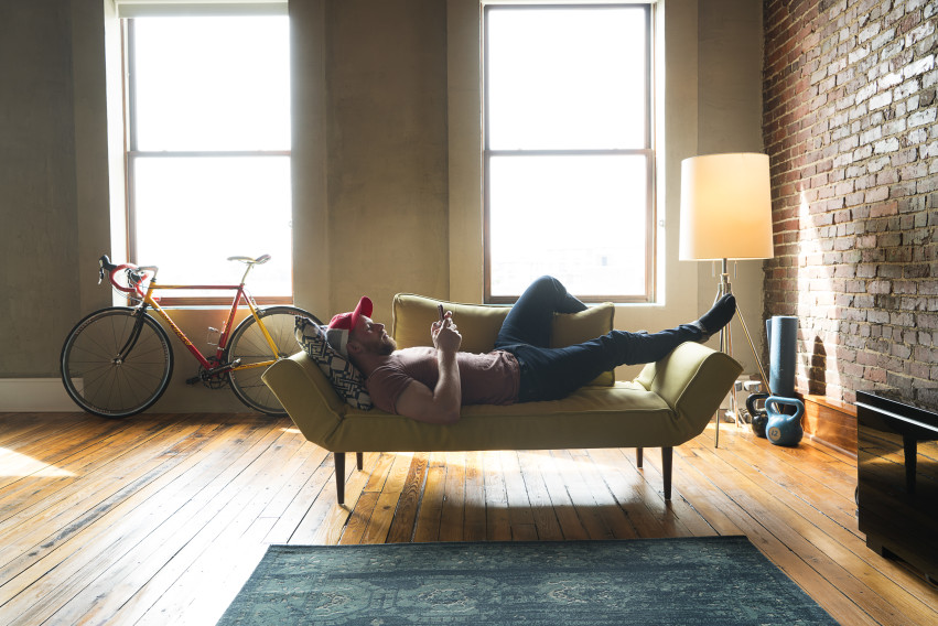 Man laying on couch inside of apartment