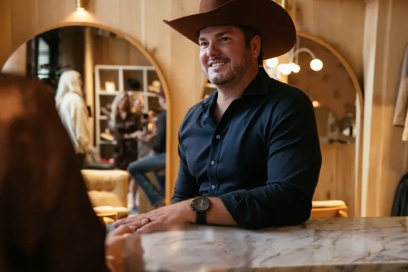 Man trying on a cowboy hat in a local Tennessee hat store