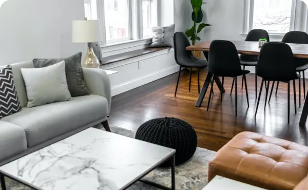 Living room furniture and kitchen table in condo with dark hard wood floors