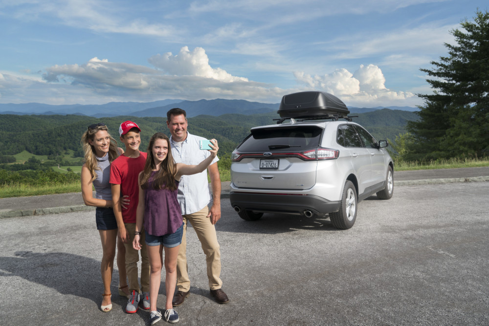 Family in Tennessee mountains taking picture next to their car