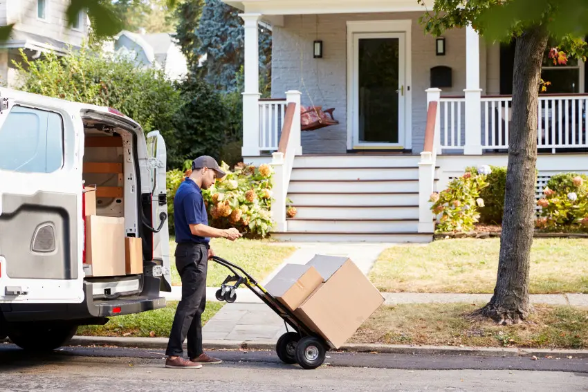 Delivery driver unloading packages to complete home delivery