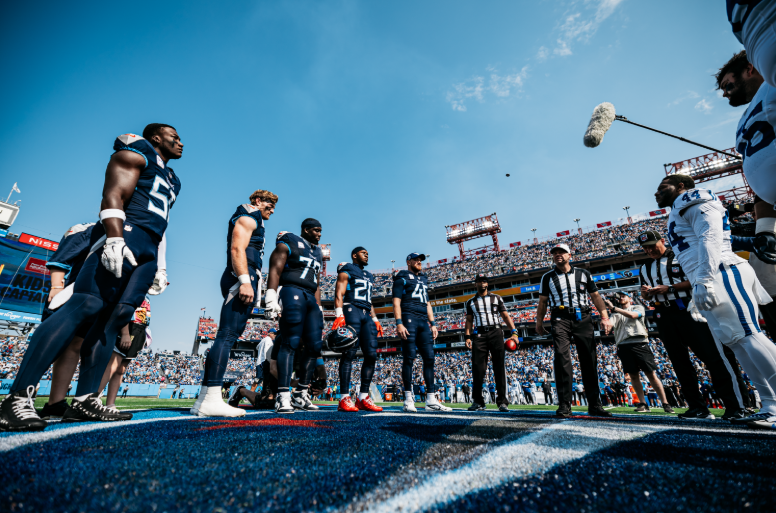 Tennessee Titans football players gathered around for cointoss in a game at Nissan Stadium