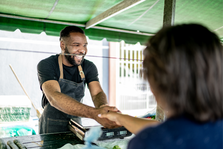 Small business owner shaking hands with one of his customers