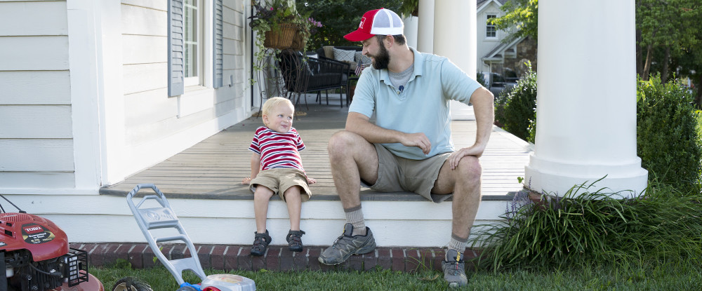 Man sitting on a porch with his child.