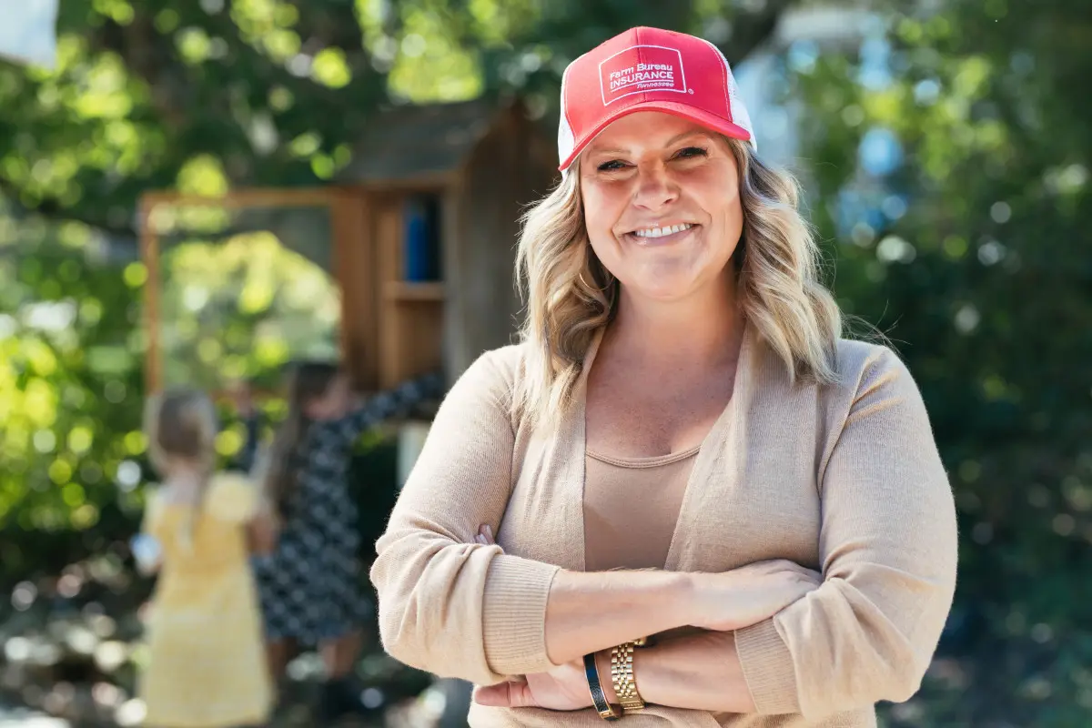 Farm Bureau Insurance of Tennessee insurance agent wearing red hat with kids in background