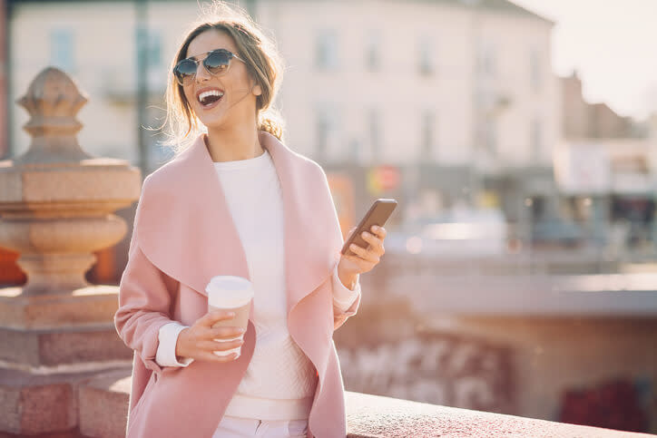 Piękna kobieta spaceruje i robi zakupy przez aplikację mobilną
