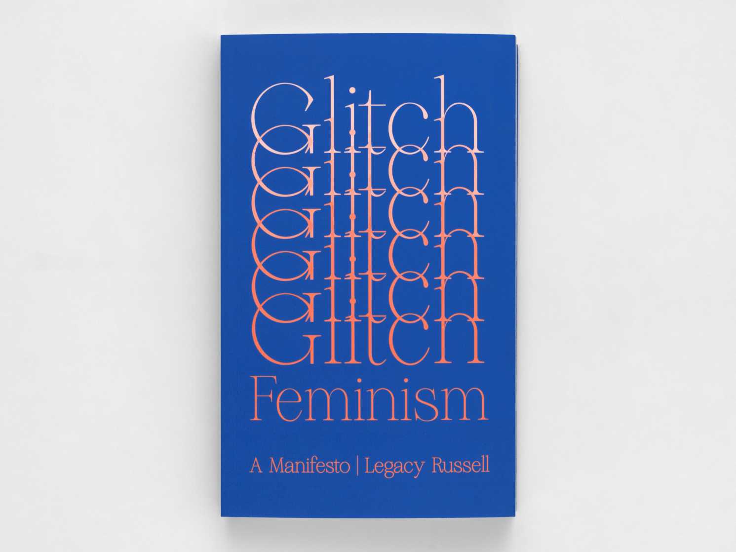Tall dark blue book with the word "Glitch" in a repeating pattern, sliding from the top of the page to just above the bottom. The word "Feminism" is just below this followed by "A Manifesto" and the author, Legacy Russell's name. The text is printed in a white to peach gradient.