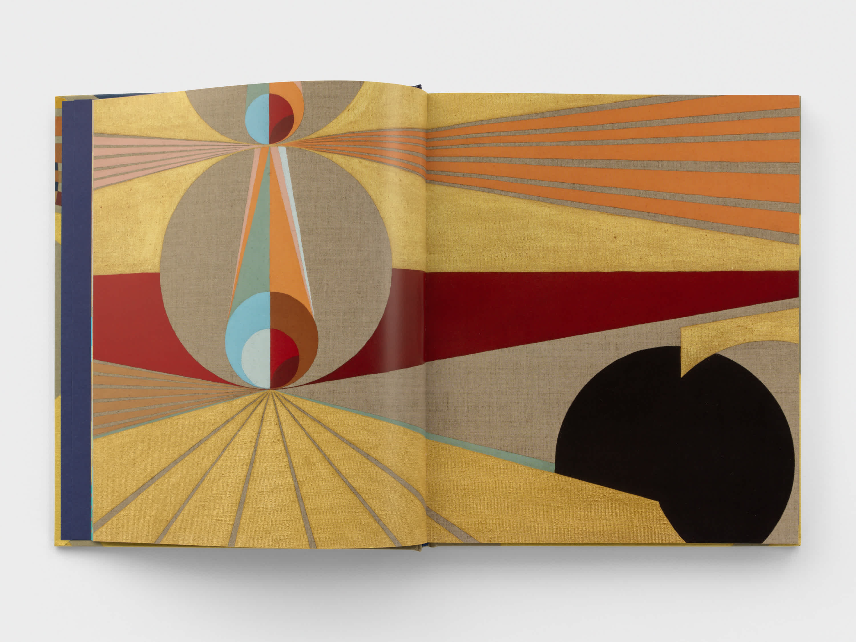 Open book with yellow, red, and sand geometric artwork on both pages.