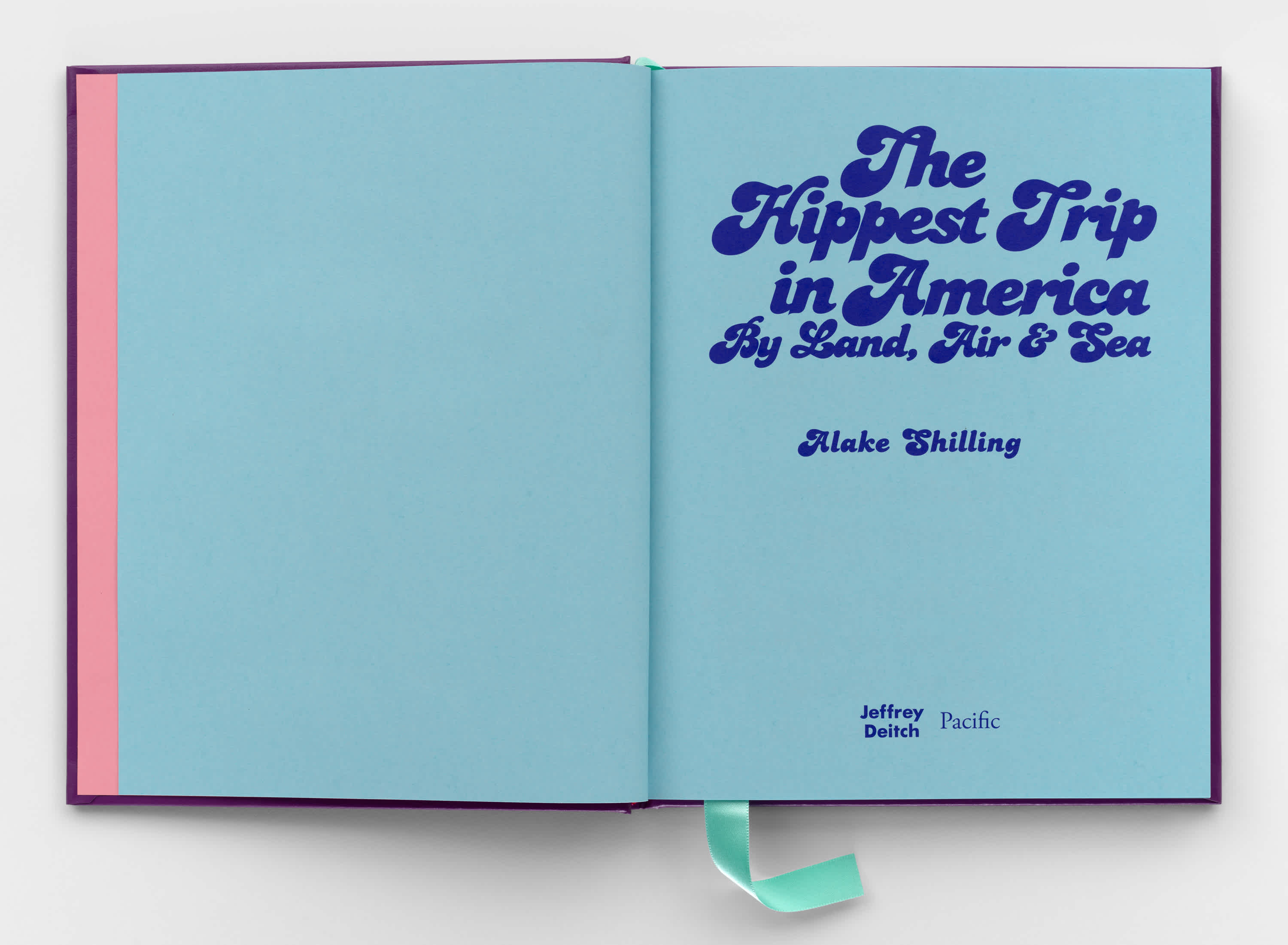 Both pages of the open book are bright blue. A strip of pink can be seen between the open cover and the left page. Dark blue psychedelic letters take up most of the right page. A light blue ribbon sticks out of the bottom center of the book, near the binding.