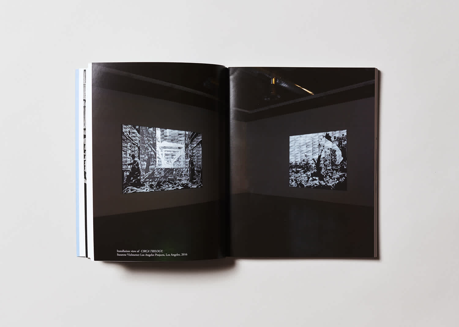 Centerfold of a book that features an installation shot with two projected films on the walls.