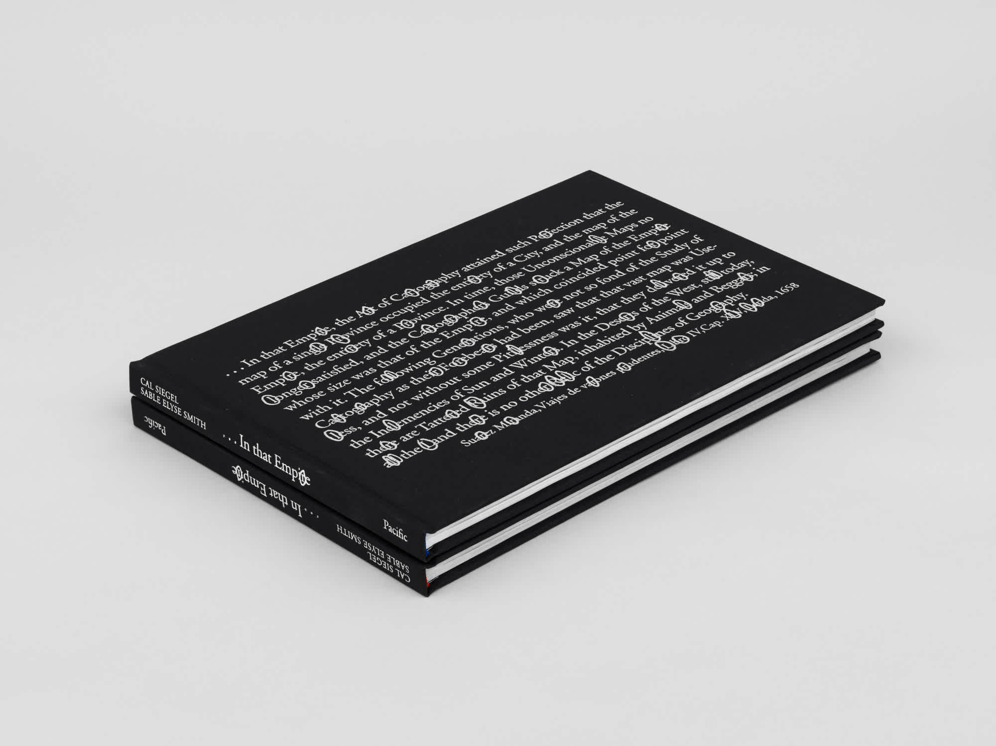 Two black rectangular books stacked on top of each other. The spines are visible.