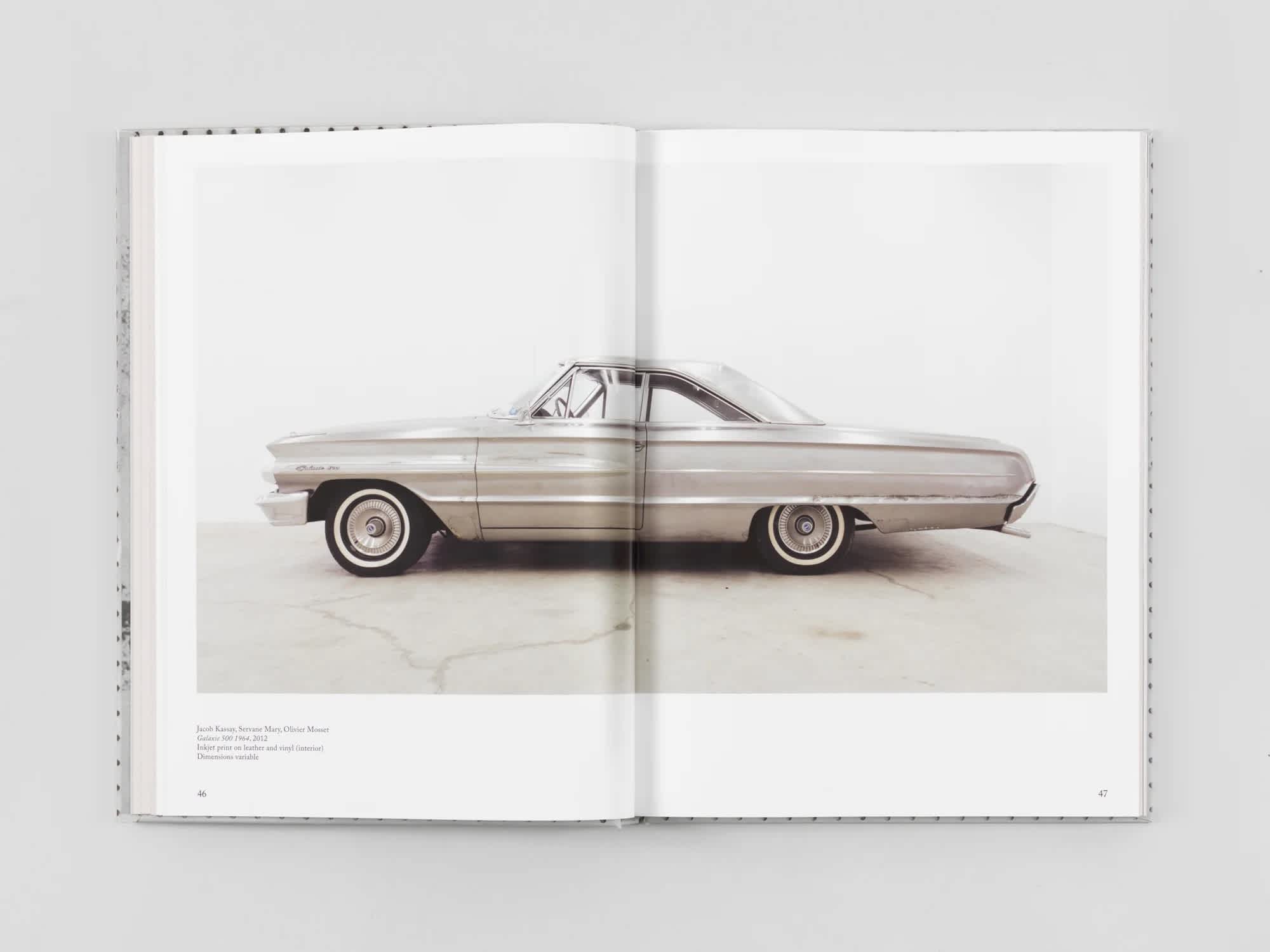 Open book with a centerfold image of a silver car.