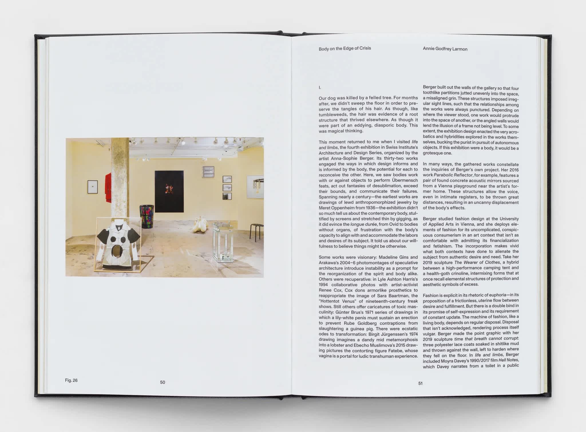 Open book with an exhibition photograph on the left page. Two columns of text are on the right page.