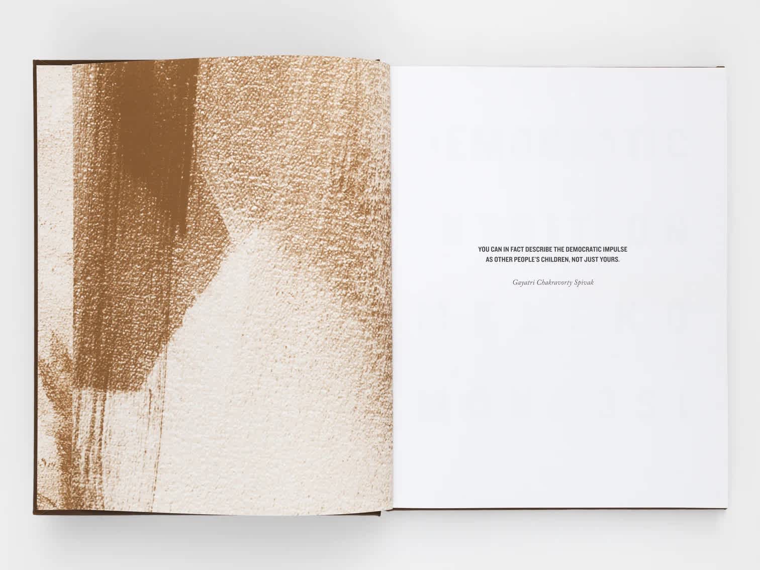 Open book with brown abstract artwork detail on the left page and three lines of text in the center of the right page.