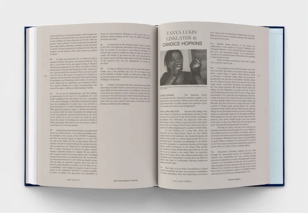 Open book with cream pages and two columns of black text. The right page has a single image at the top of the first column.