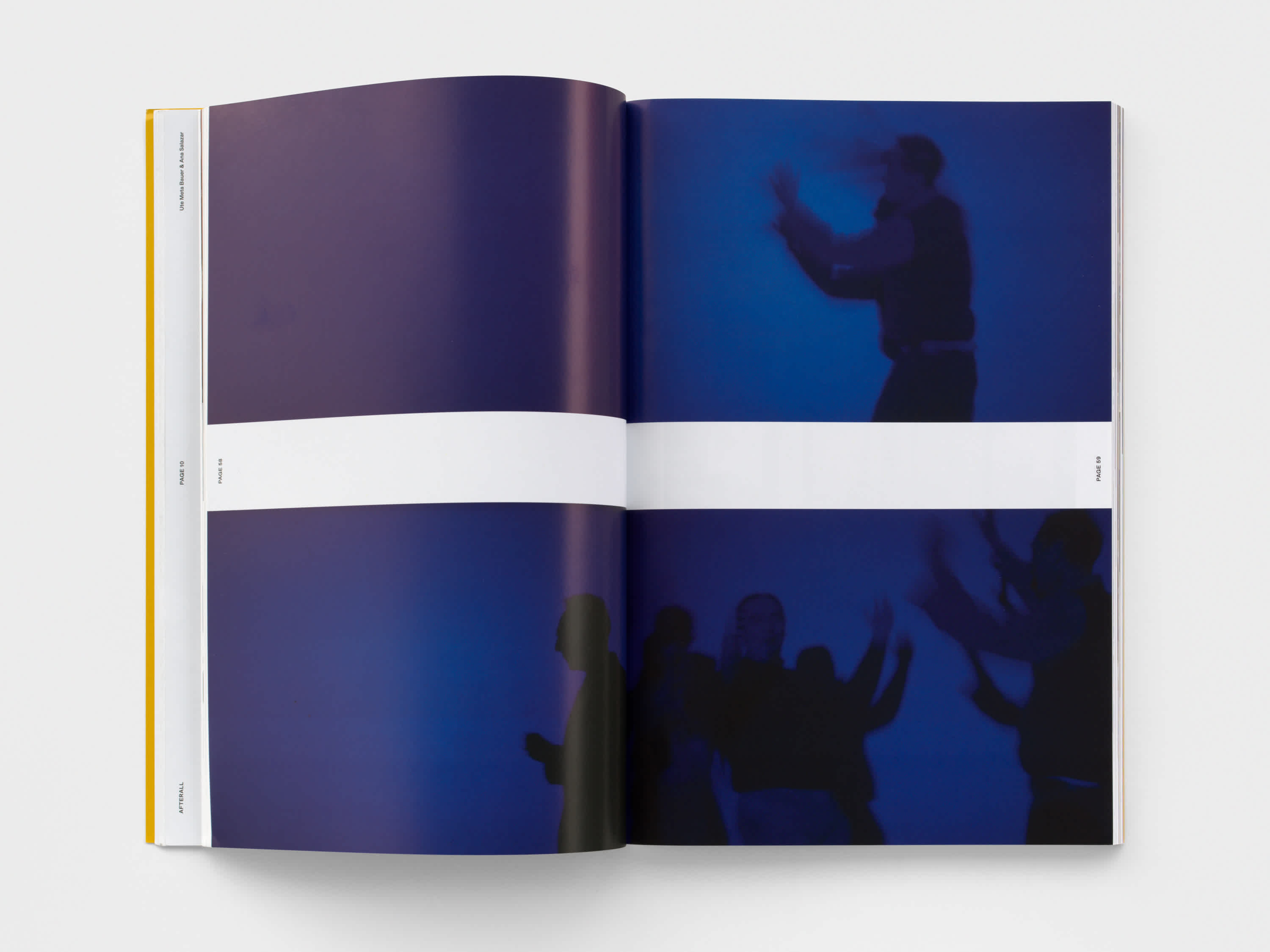 Open magazine with purple-blue centerfold image. A white band runs horizontally through the middle of the two pages.