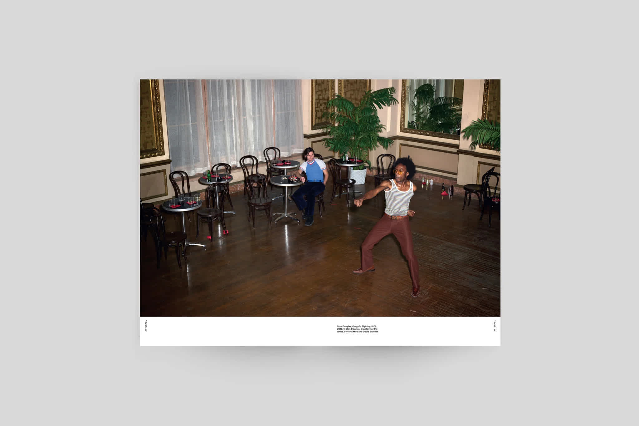 Magazine interior with a color centerfold image. A white border lines the bottom of the left and right pages. The image credit is positioned in the bottom left corner of the right page, near the binding.