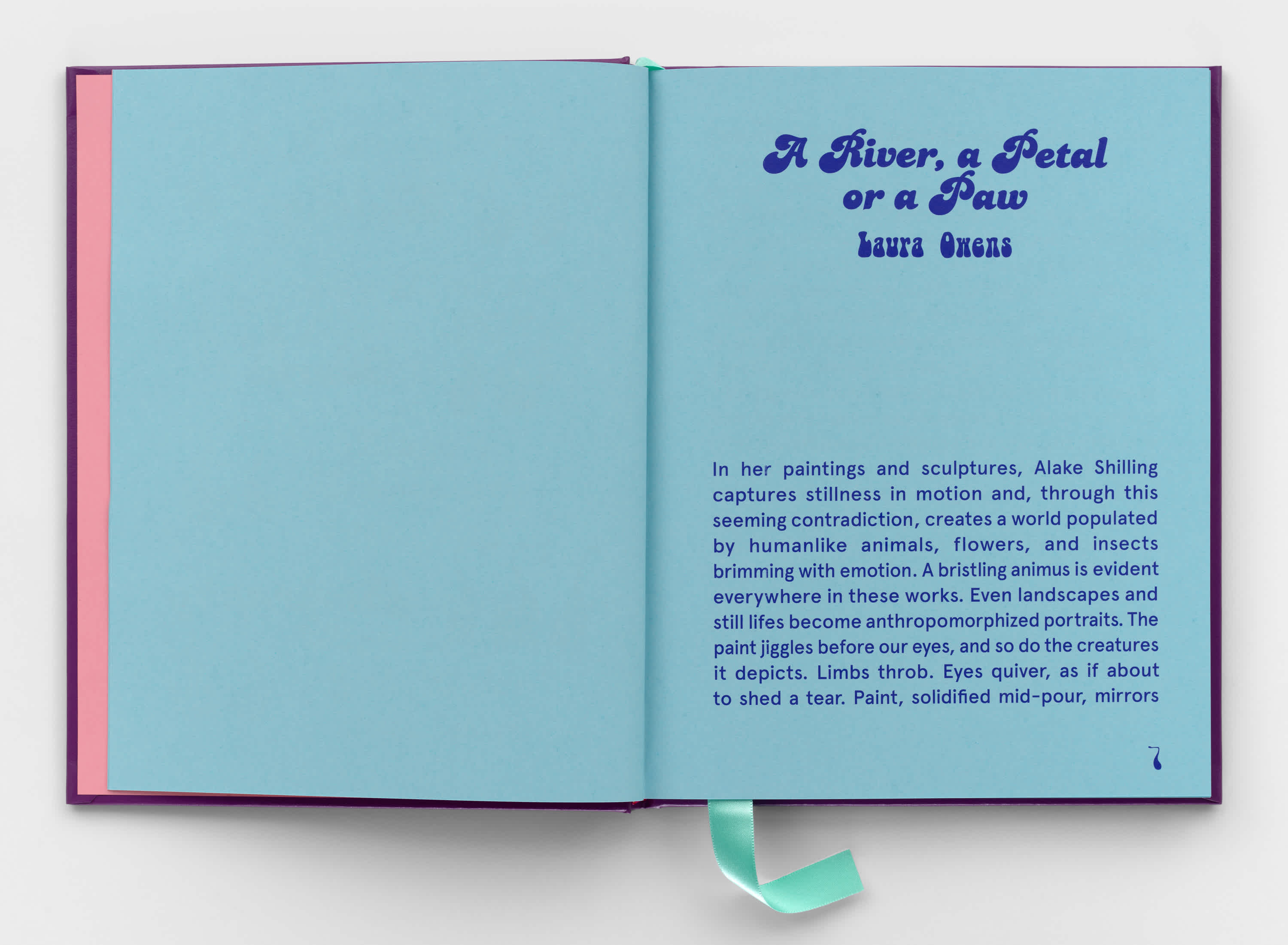 An open book with light blue pages and dark blue text. A turquoise ribbon sticks out of the bottom of the book, near the binding.