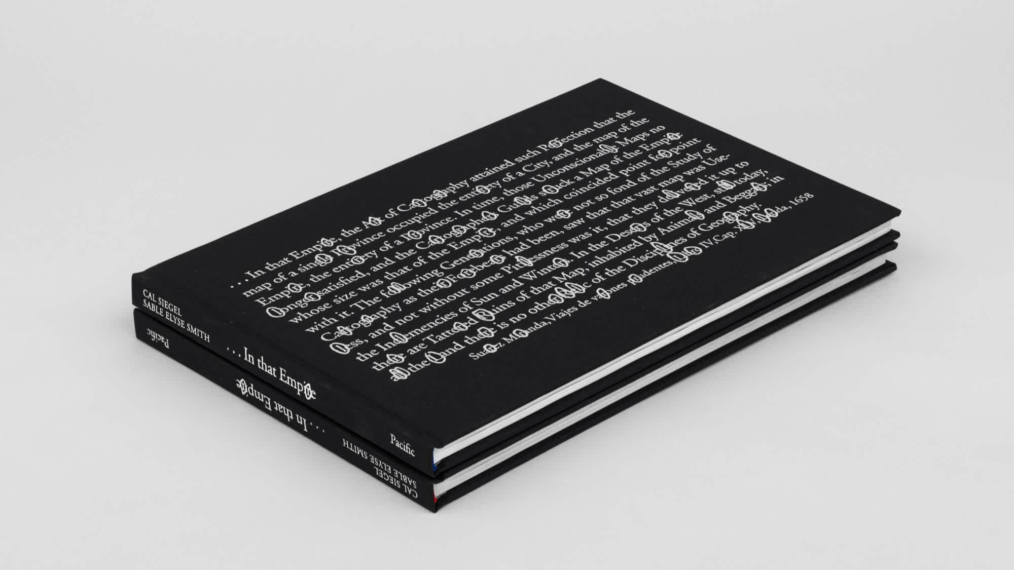 Two black rectangular books stacked on top of each other. The spines are visible.