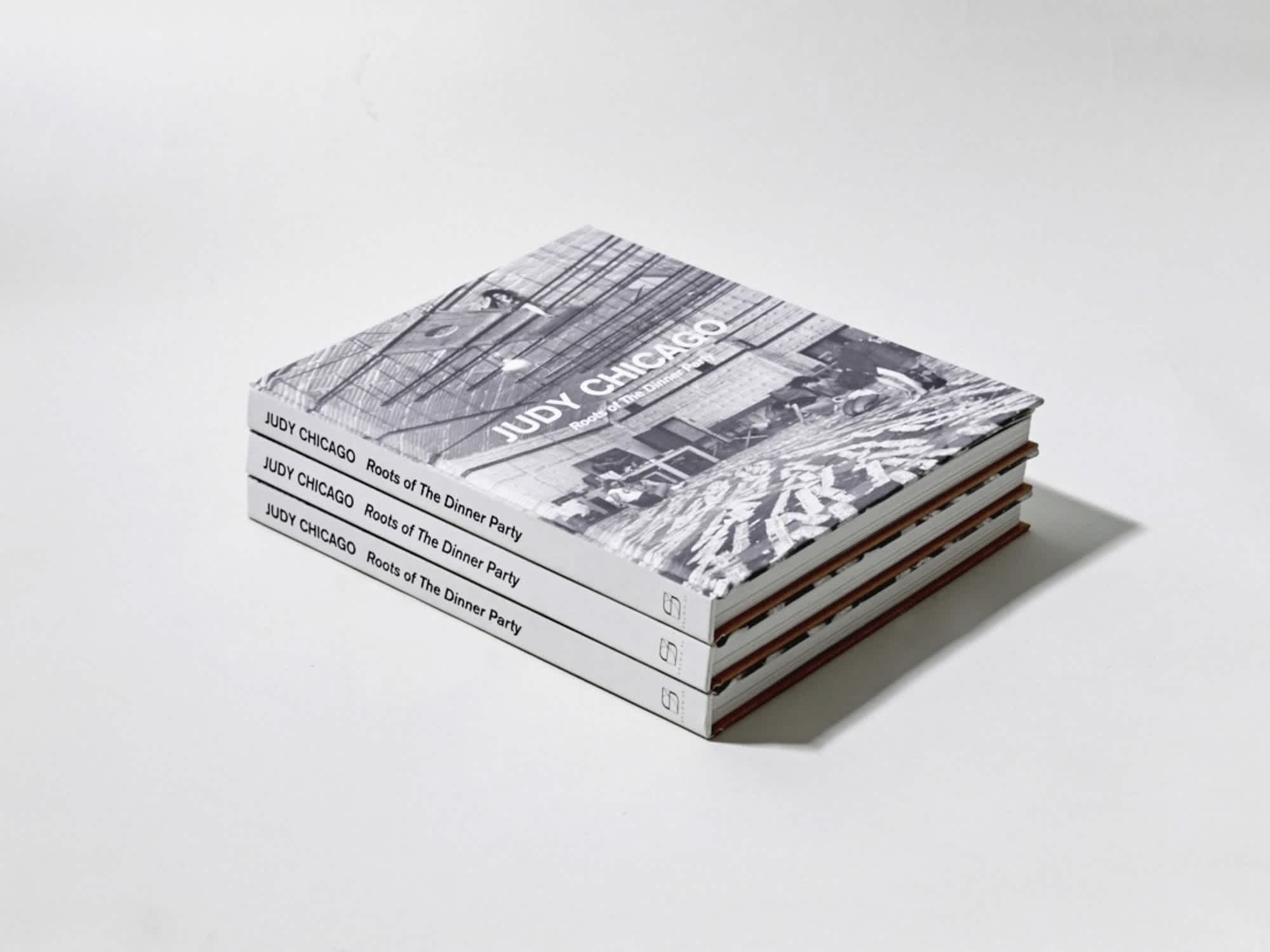 Stack of three books. The cover of the top book features a black and white photograph over which is white text. The spines of all three books are visible.