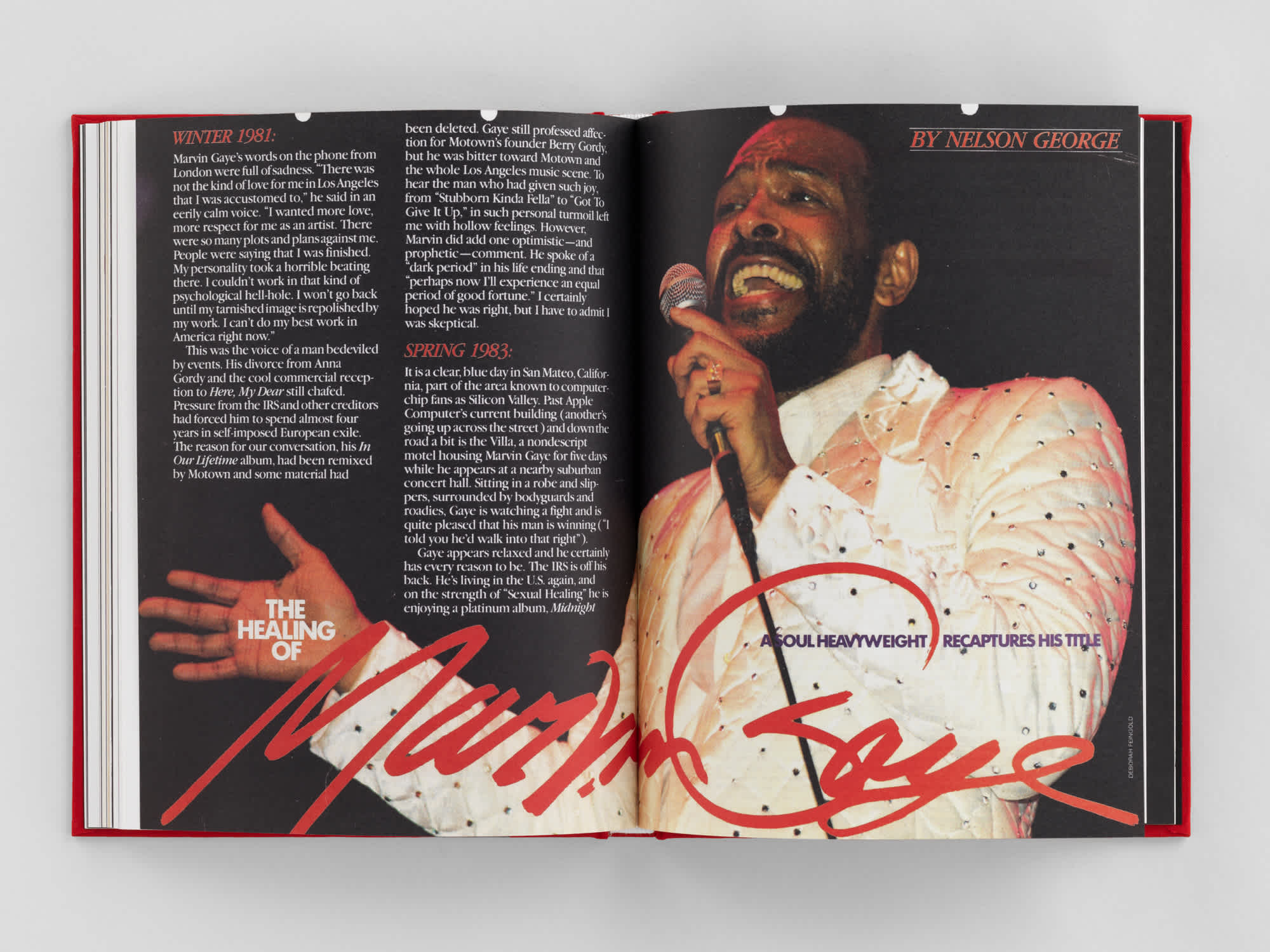 Two page spread about the artist Mavin Gaye. He sings on a black background to the right, his name is scrawled across the bottom of both pages in red. White article text in sits in the upper left corner. 