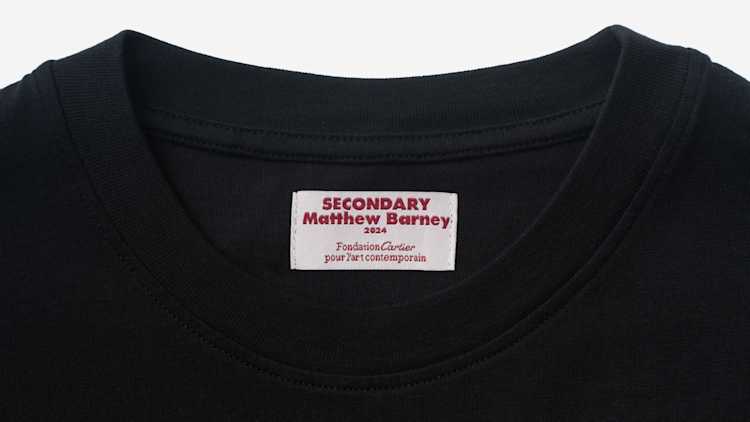 Image of a T-shirt tag which says "Secondary, Matthew Barney, 2024, Fondation Cartier pour l'art contemporain.