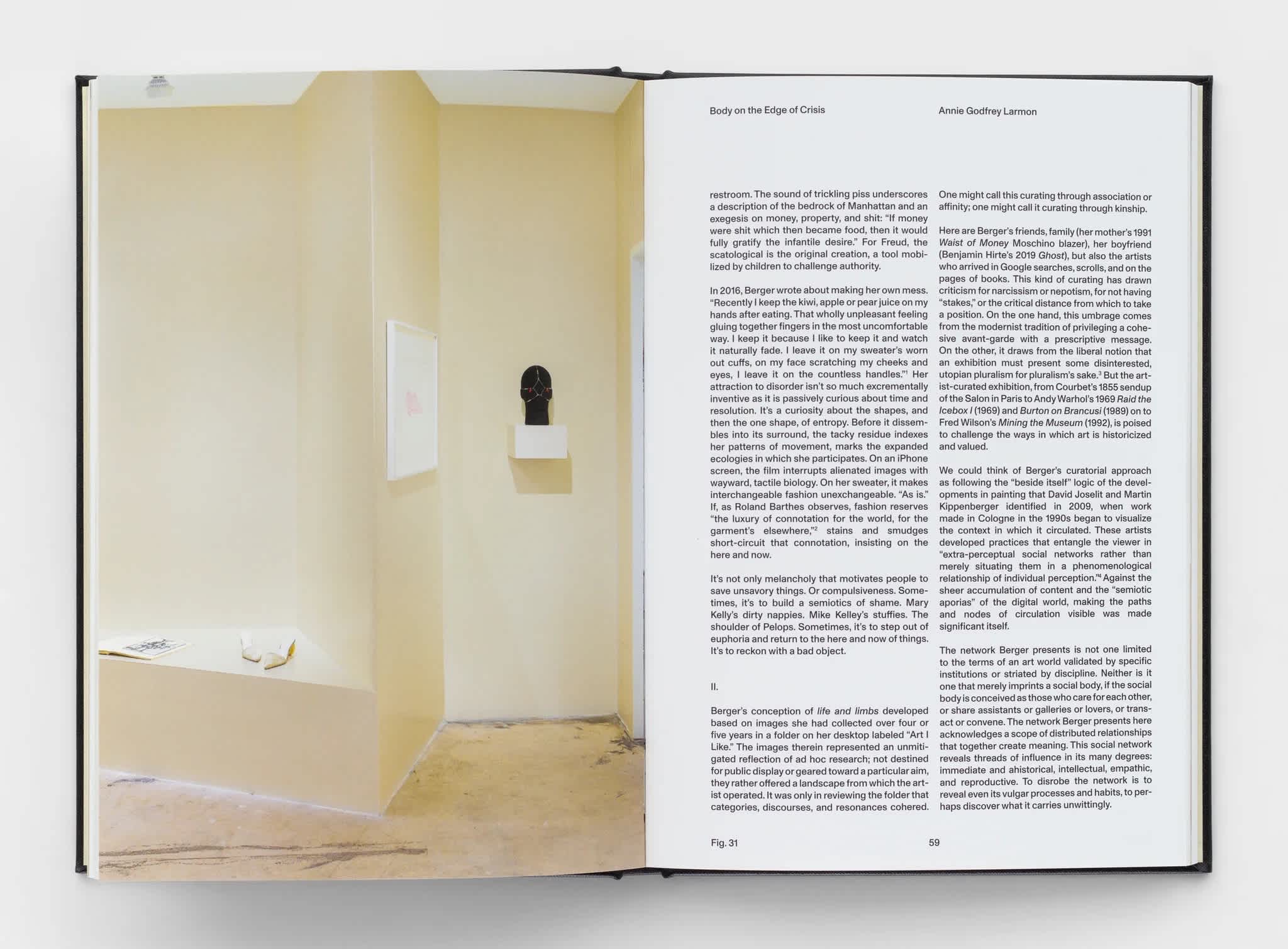 Open book with an exhibition image on the left page. Two columns of text are on the right page.
