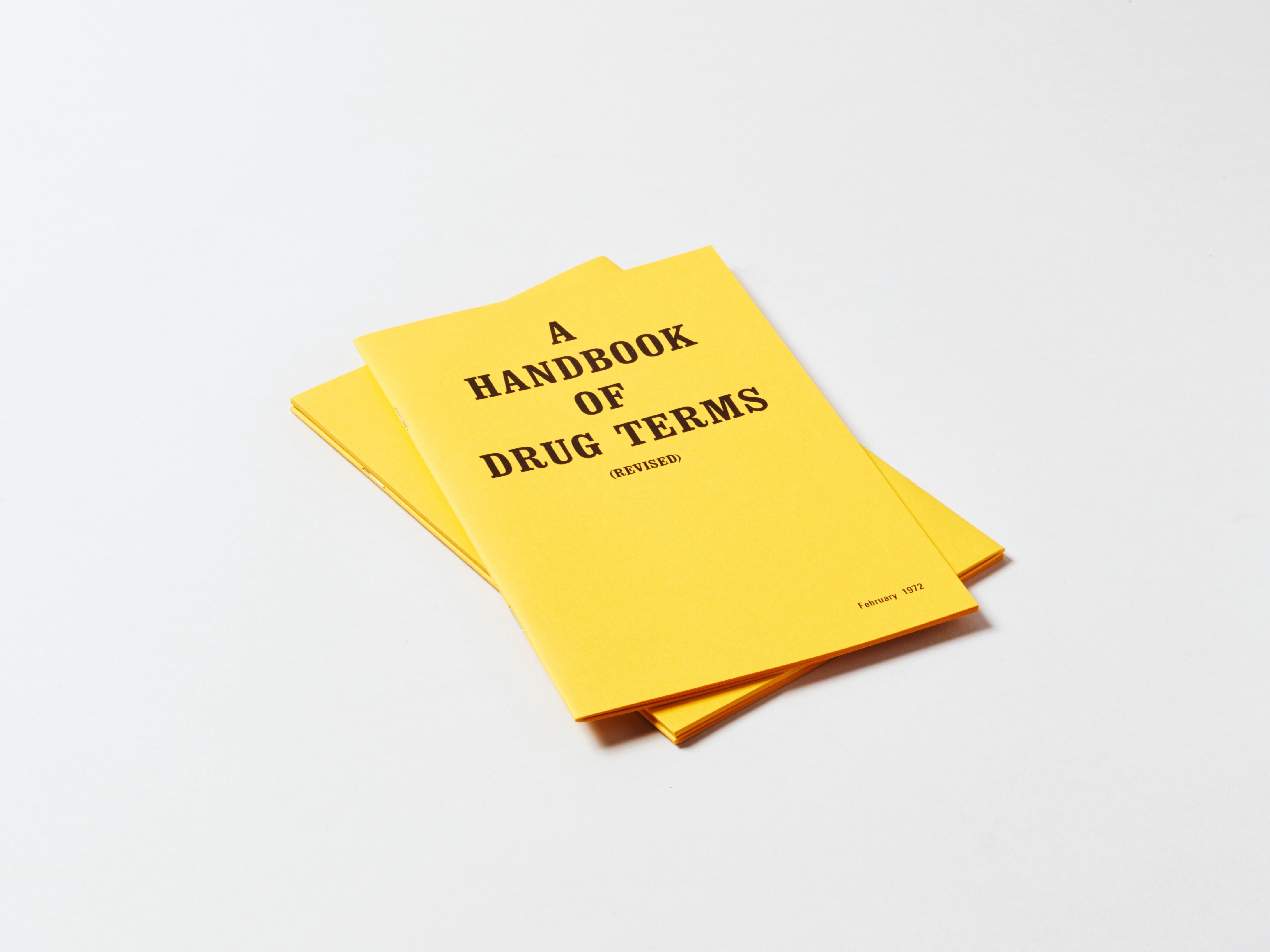 Two bright yellow books, with black text, stacked on top of one another.