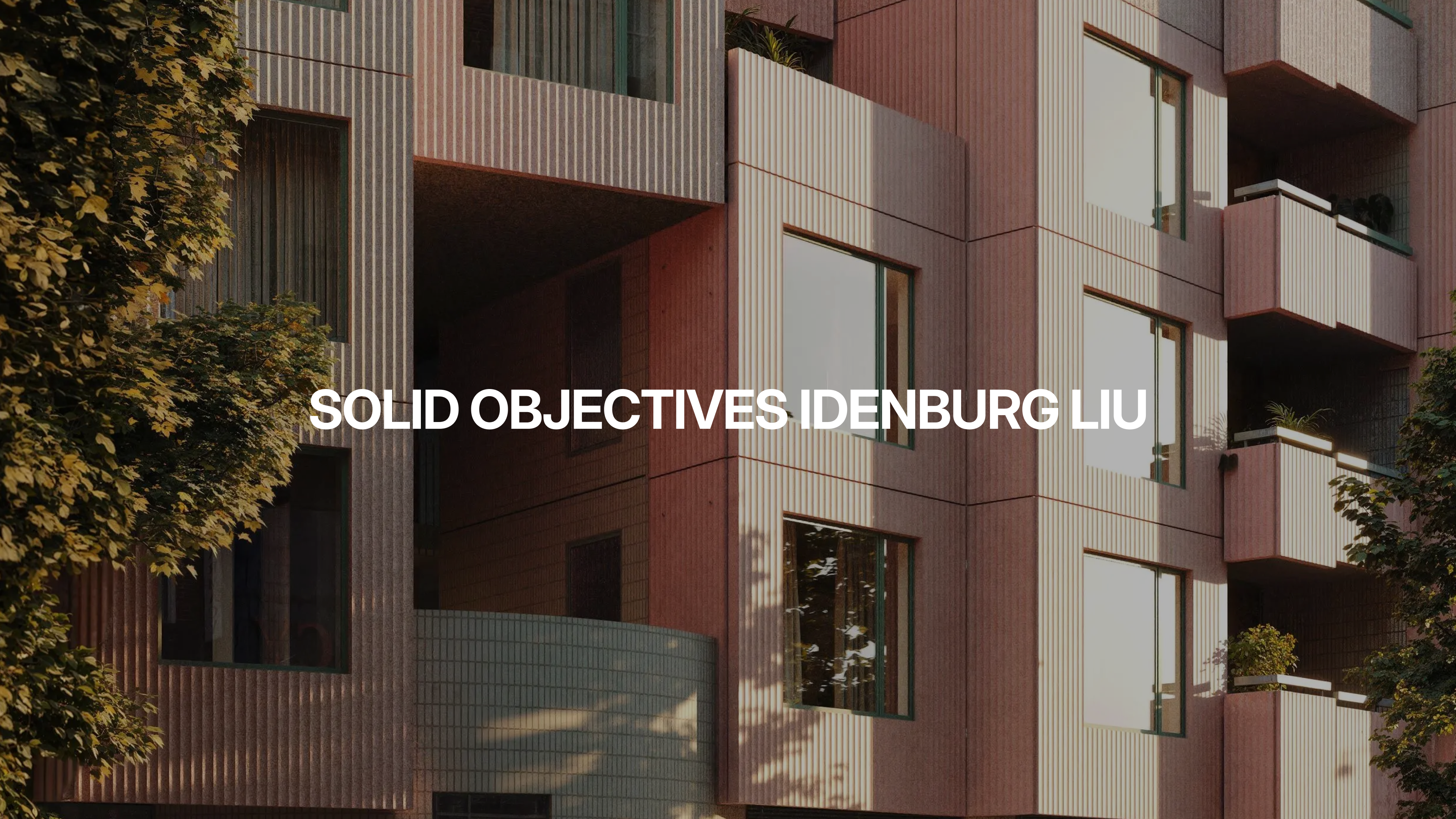 Modern apartment building with pink-toned exterior panels and large windows. Sunlight casts shadows from nearby trees onto the facade. Text over the image reads, SOLID OBJECTIVES IDENBURG LIU.