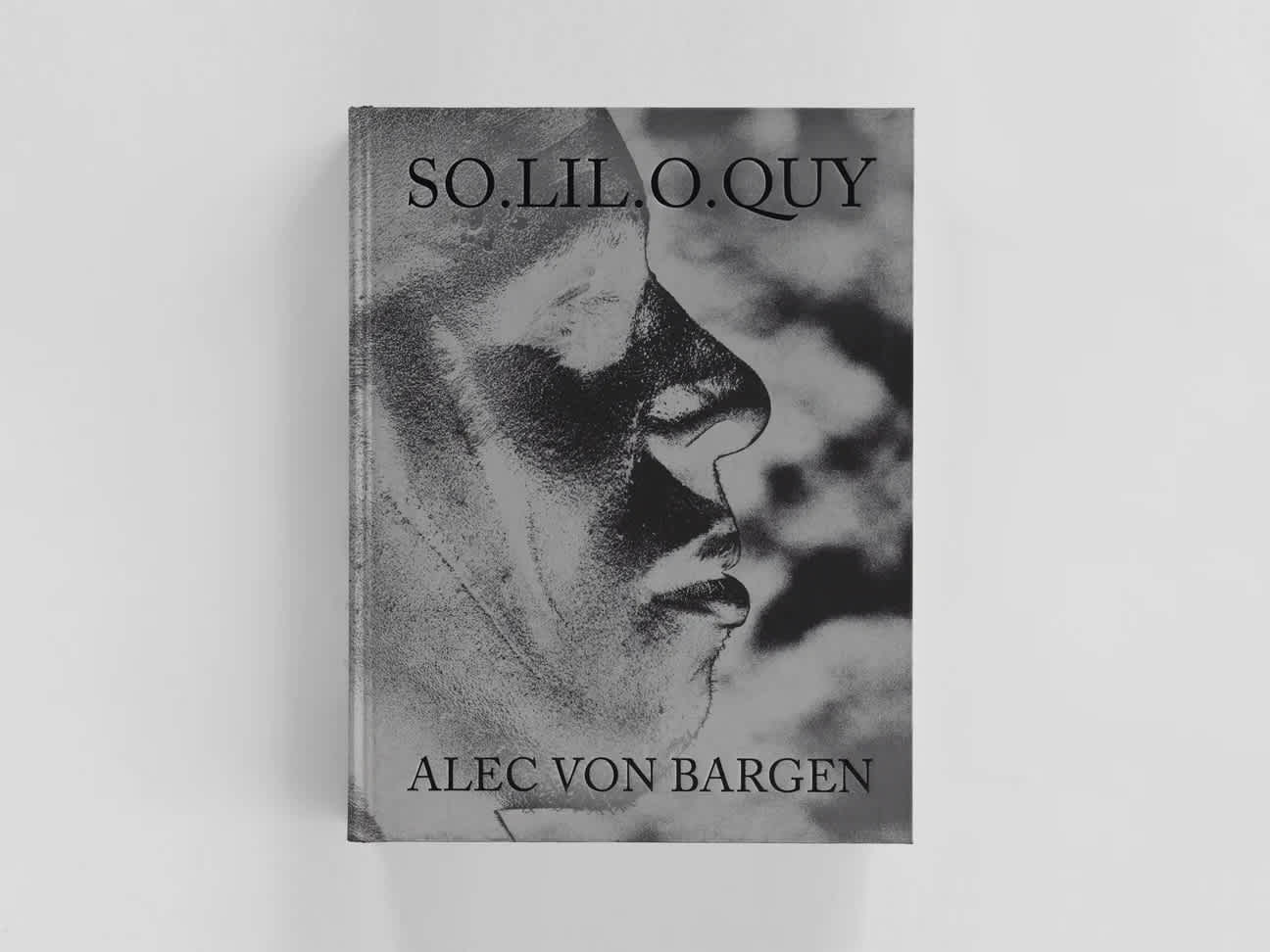 Front cover of book. The title and artist are at the top and bottom of the cover. A black and white side-profile of a man's face makes up the background.