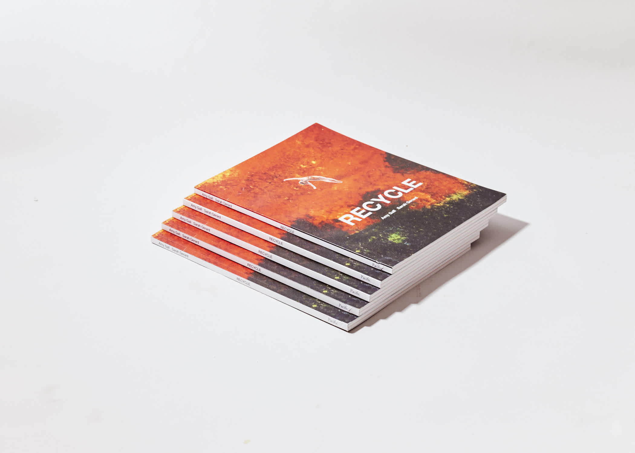 Stack of five books. The front cover is orange-red and green. The spines are visible.

