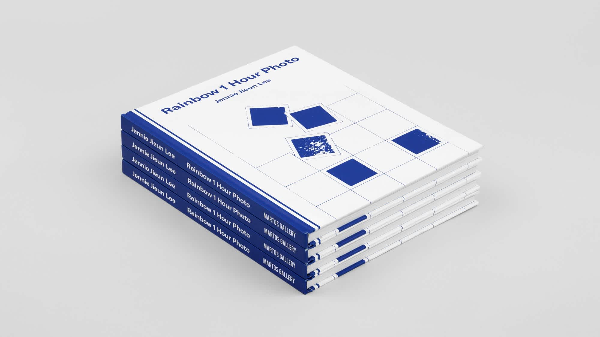 Stack of four blue and white books positioned diagonally in the frame so the spines are visible.