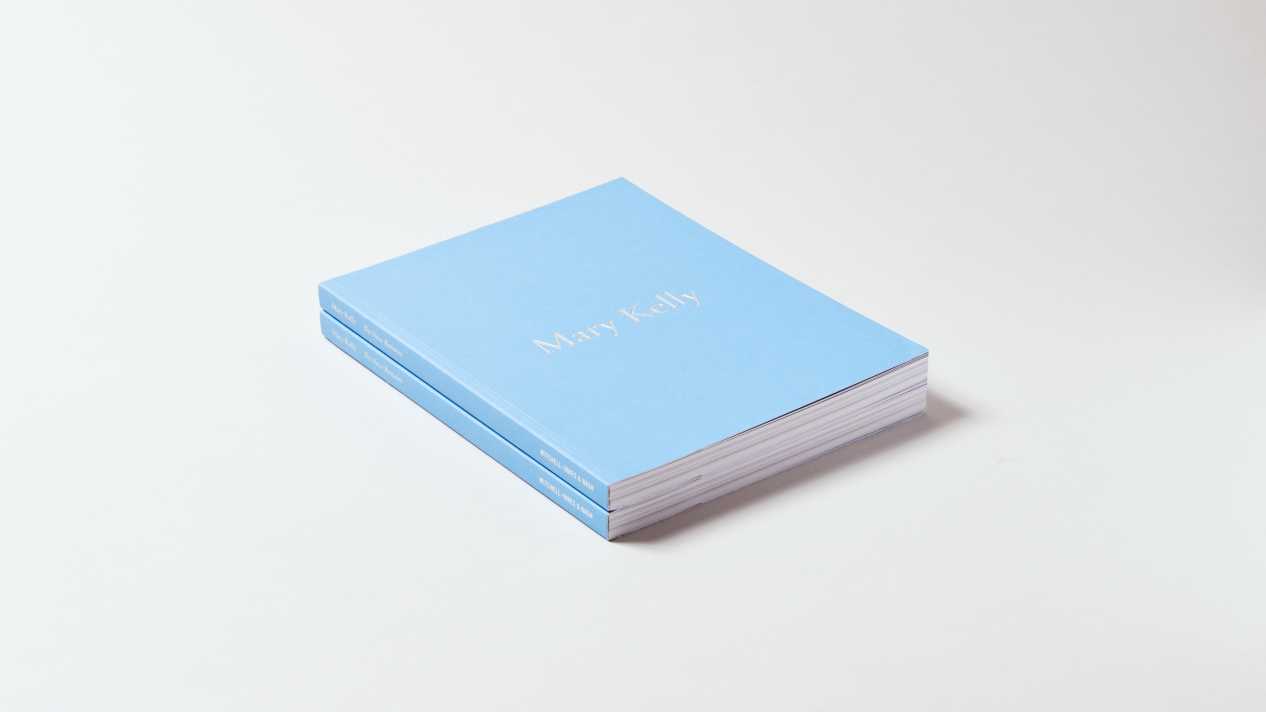 Two light blue books stacked on top of each other. The spine and bottom of the book are visible. The title is printed in light gray letters in the center of the front cover.