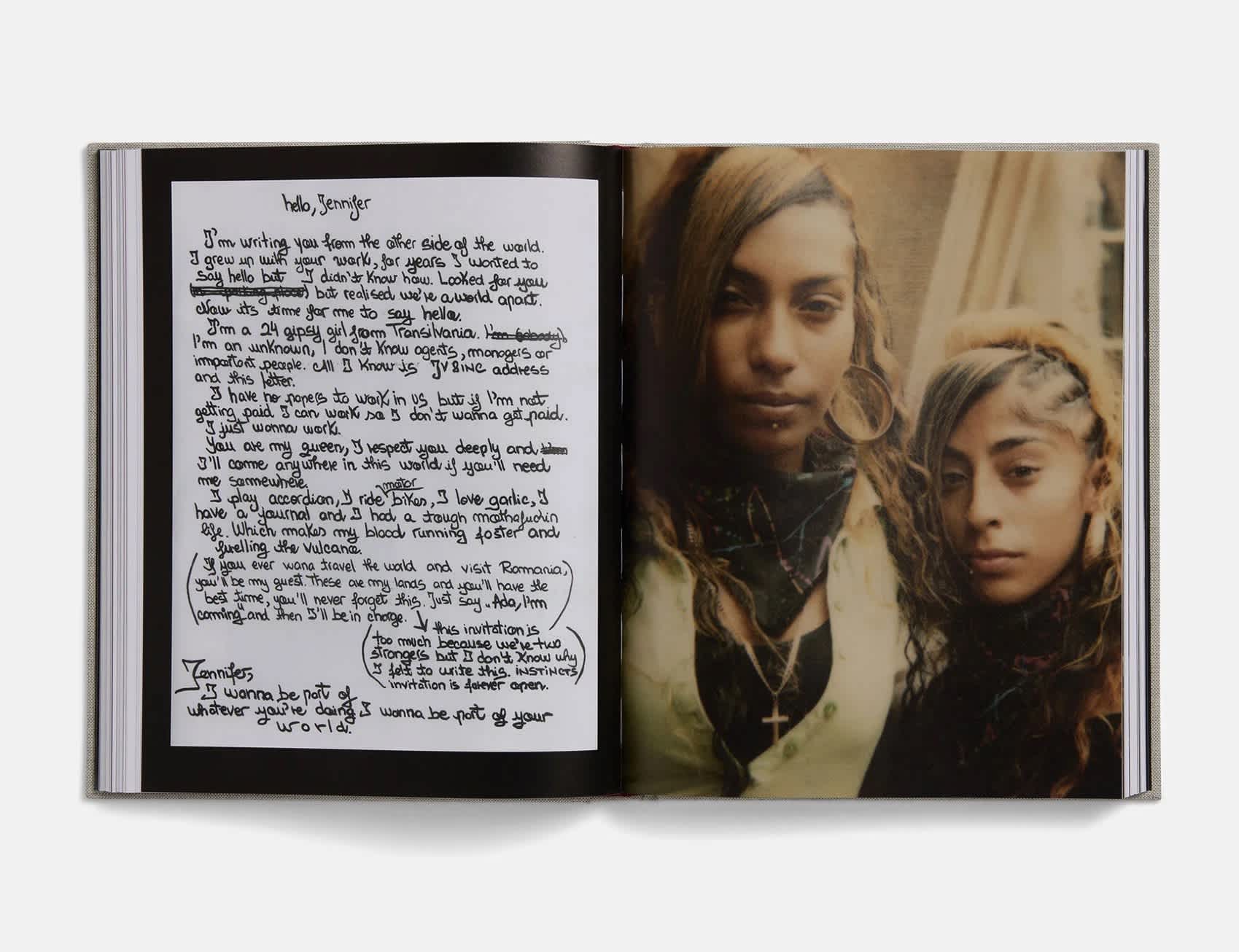 Book interior. The left page is a scan of a letter imposed on a black background. The right page is a photograph of two girls, the one on the left is taller. The photo has an overall yellow-orange hue.