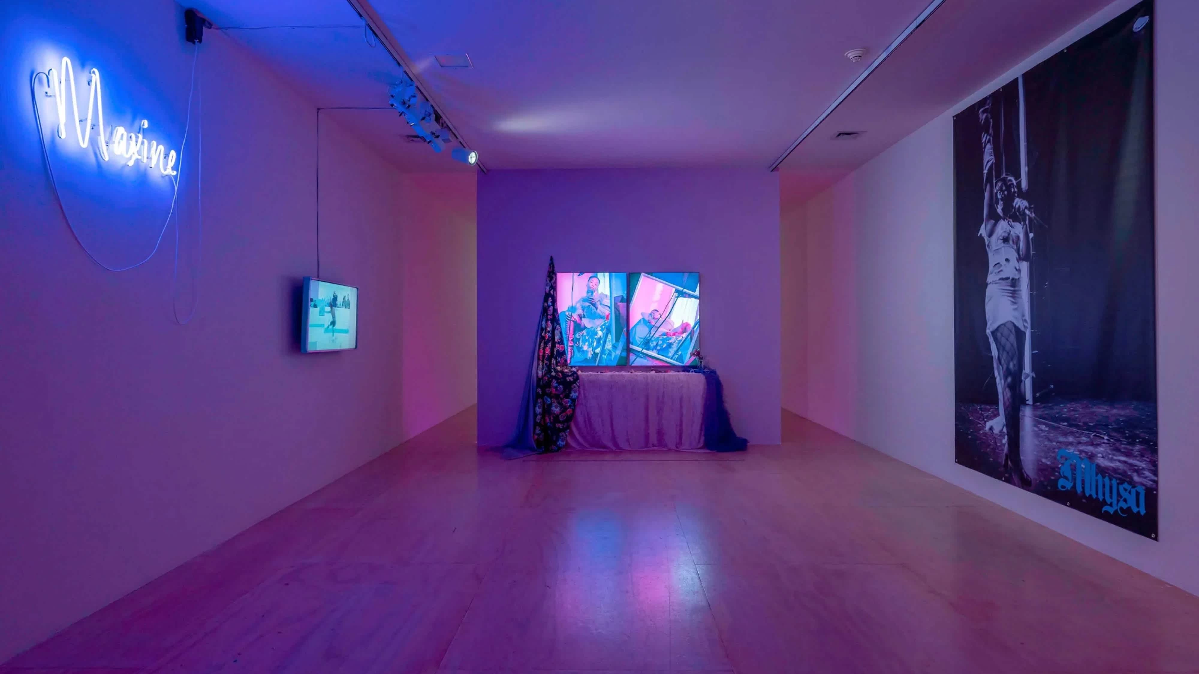 Purple lighted room with four artworks on the three walls.