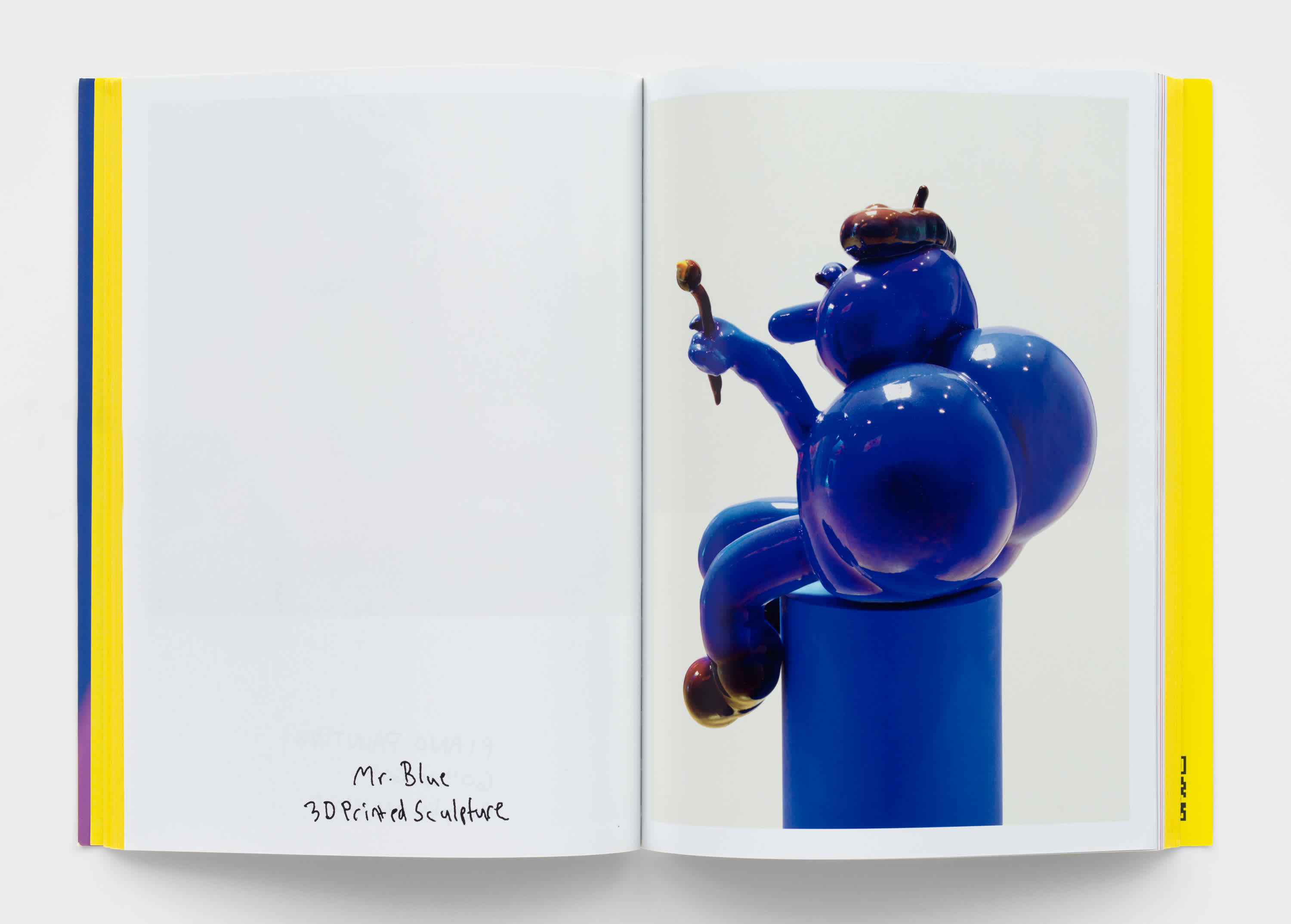 An open book with a photograph of a blue sculpture on the right page. Artwork title and information is on the bottom of the left page.