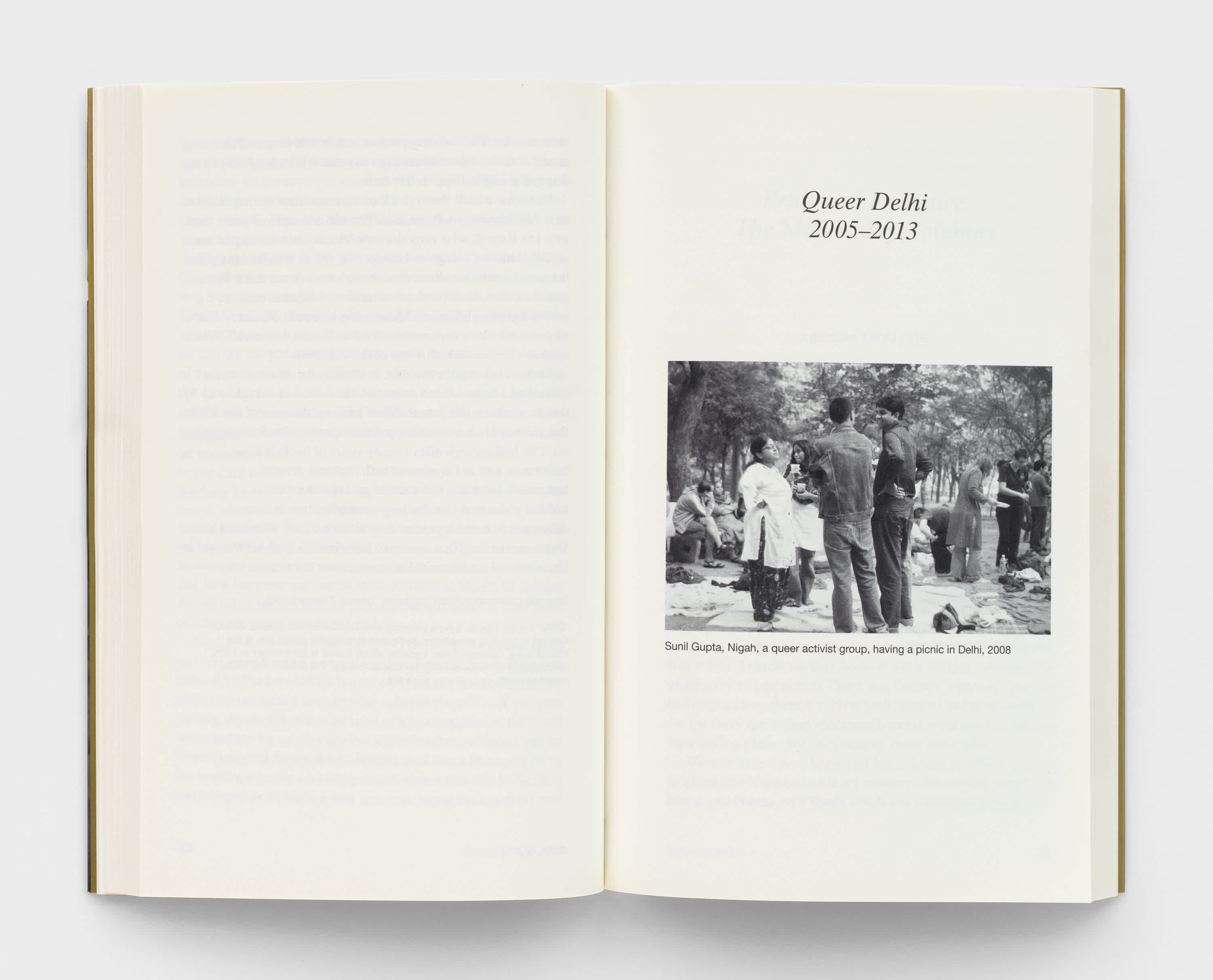 An open book with cream colored pages. The left page is blank and the right page has a title and dates above a black and white photograph of a queer activist group in Delhi, India.