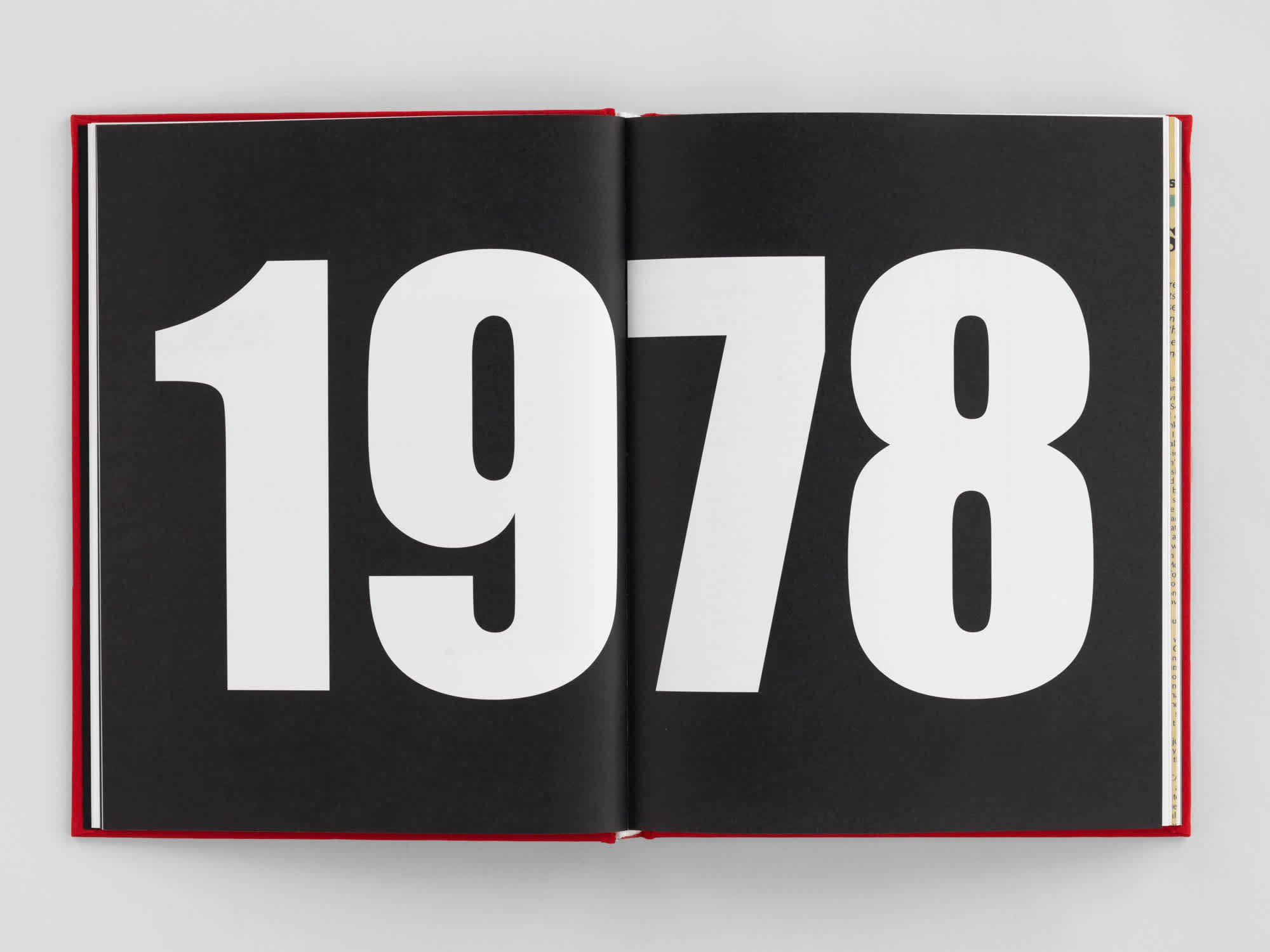 Two pages of an open book. "1978" stretches across both black pages in bold white text. 