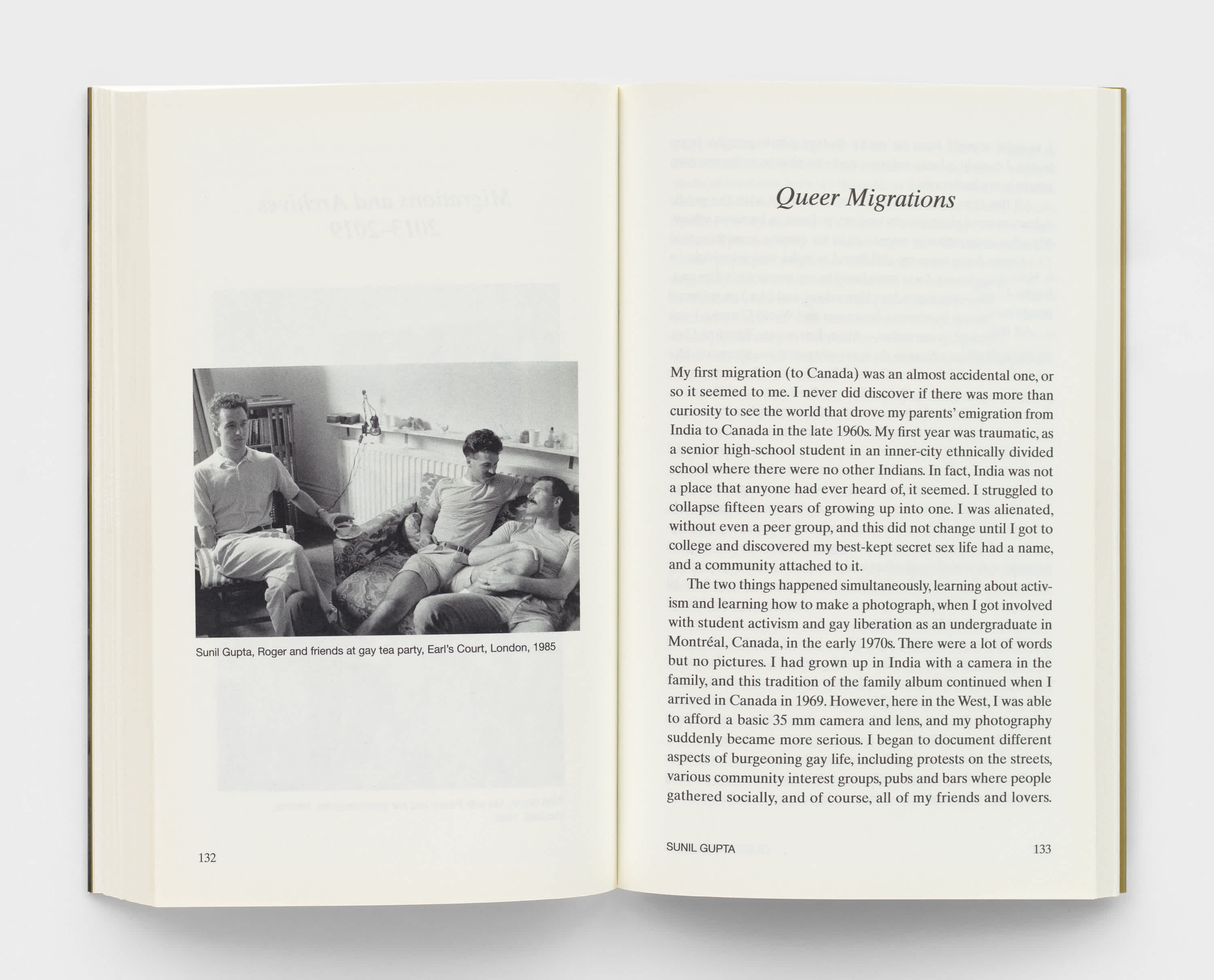 Open book with cream colored pages. A black and white photograph of three men sitting on couches is on the left page. Essay text is on the right page. 