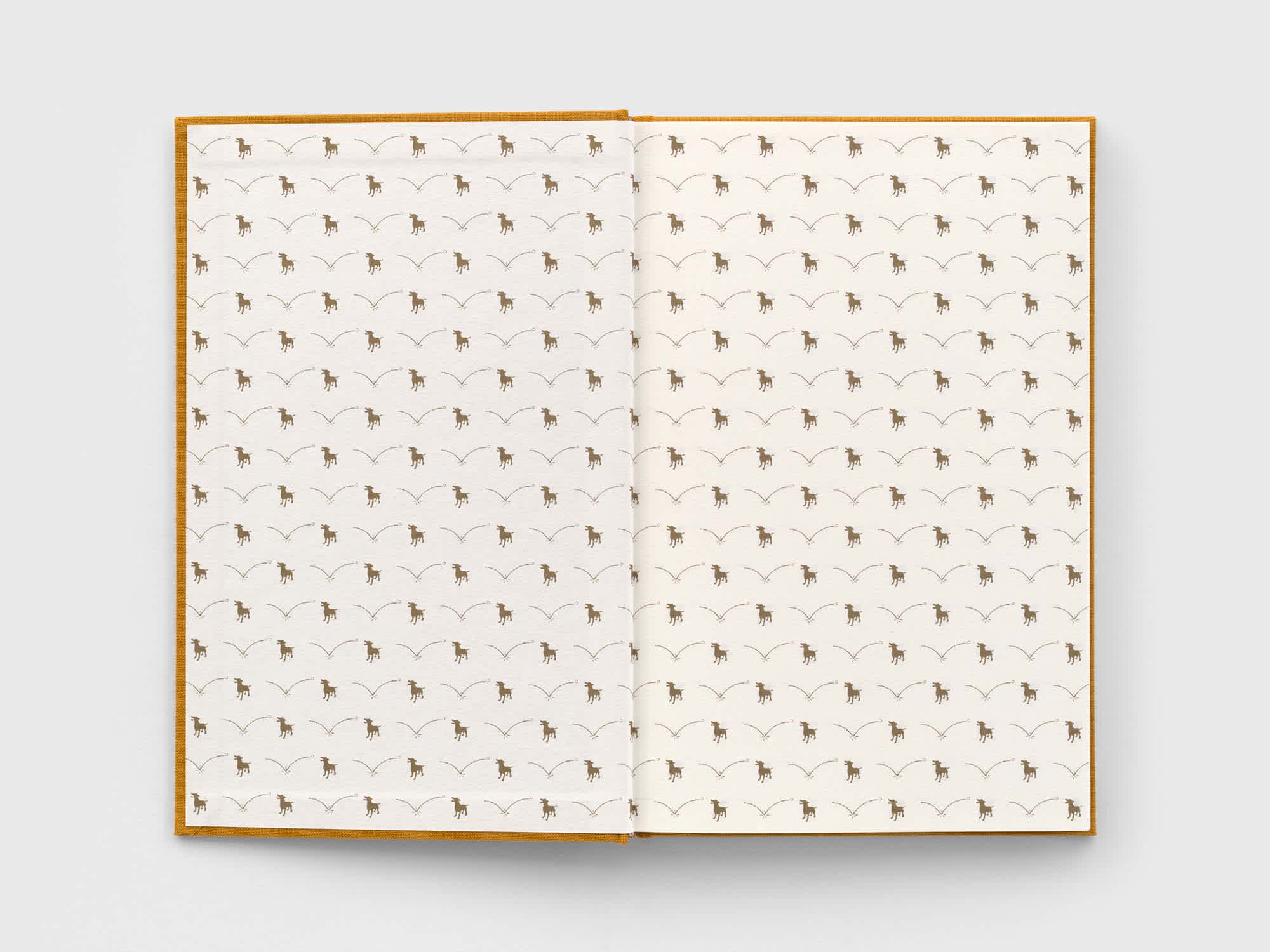 Open book with the pattern of a dog catching a ball covering the paper.