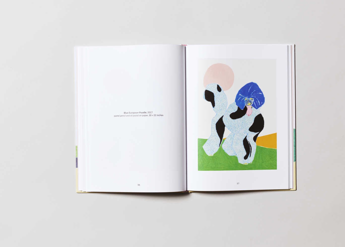 An open book with two lines of text on the left page and a painterly rendering of a colorful poodle on the right.