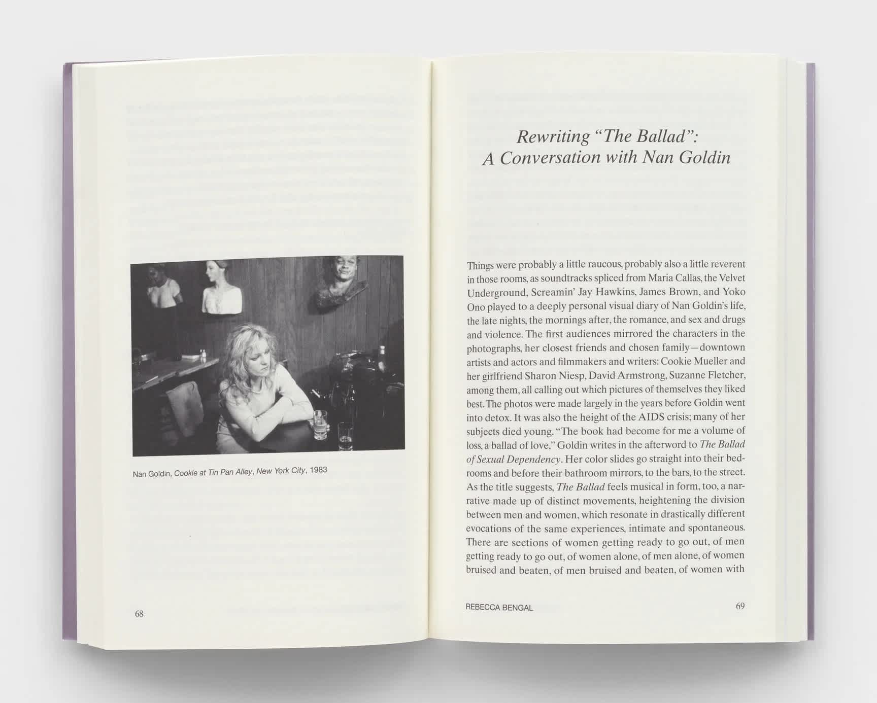 Open book with a black and white photograph on the left page and essay text on the right page.