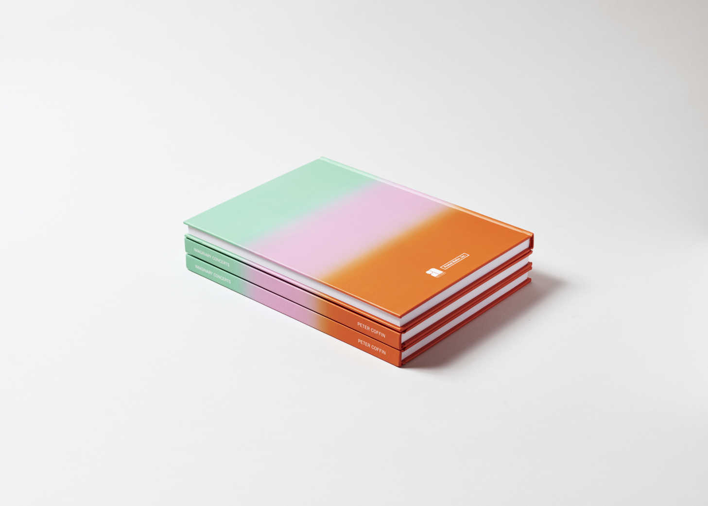 Stack of three books painted in descending swatches of green, pink and orange.