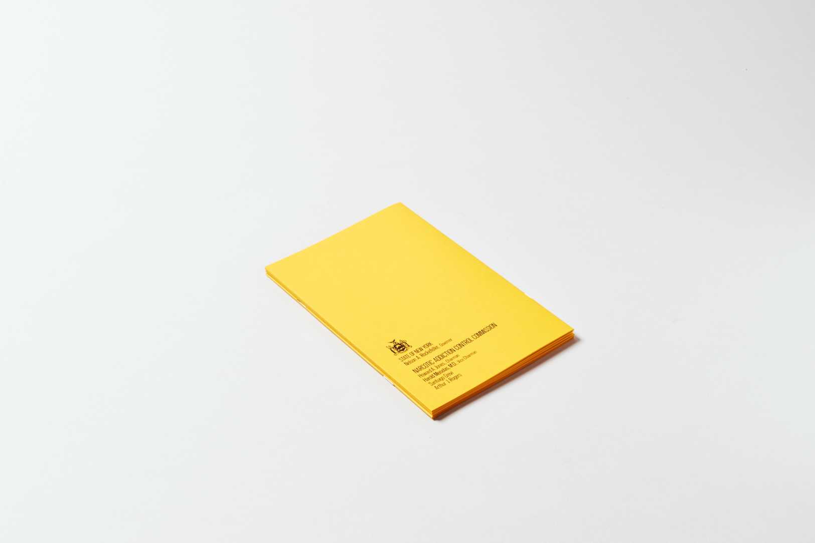 Bright yellow book laying face down. A small amount of black text is in the bottom left corner.