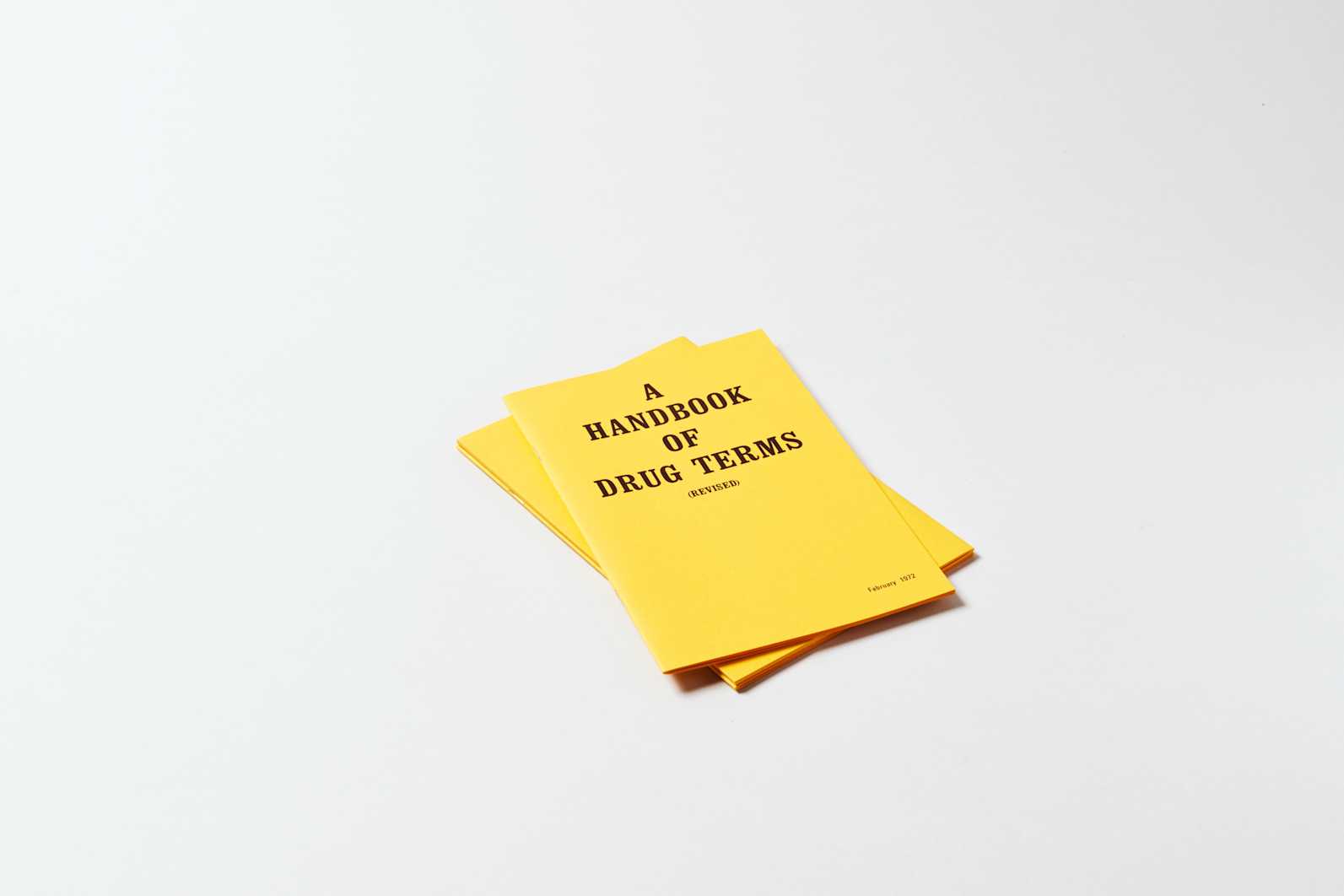 Two bright yellow books, with black text, stacked on top of one another.