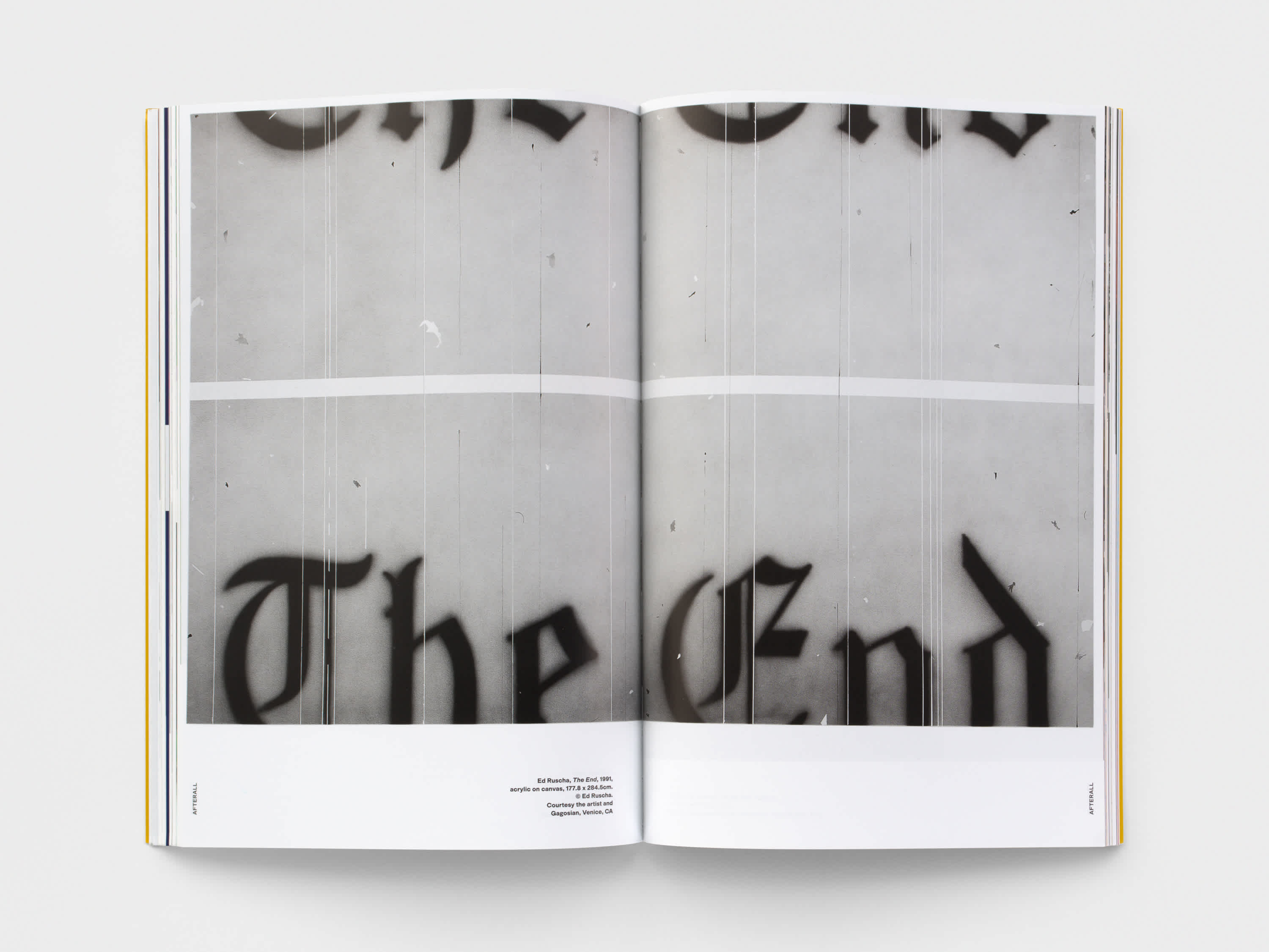 Open magazine with black and white centerfold image. A white band runs horizontally along the bottom of the two pages.