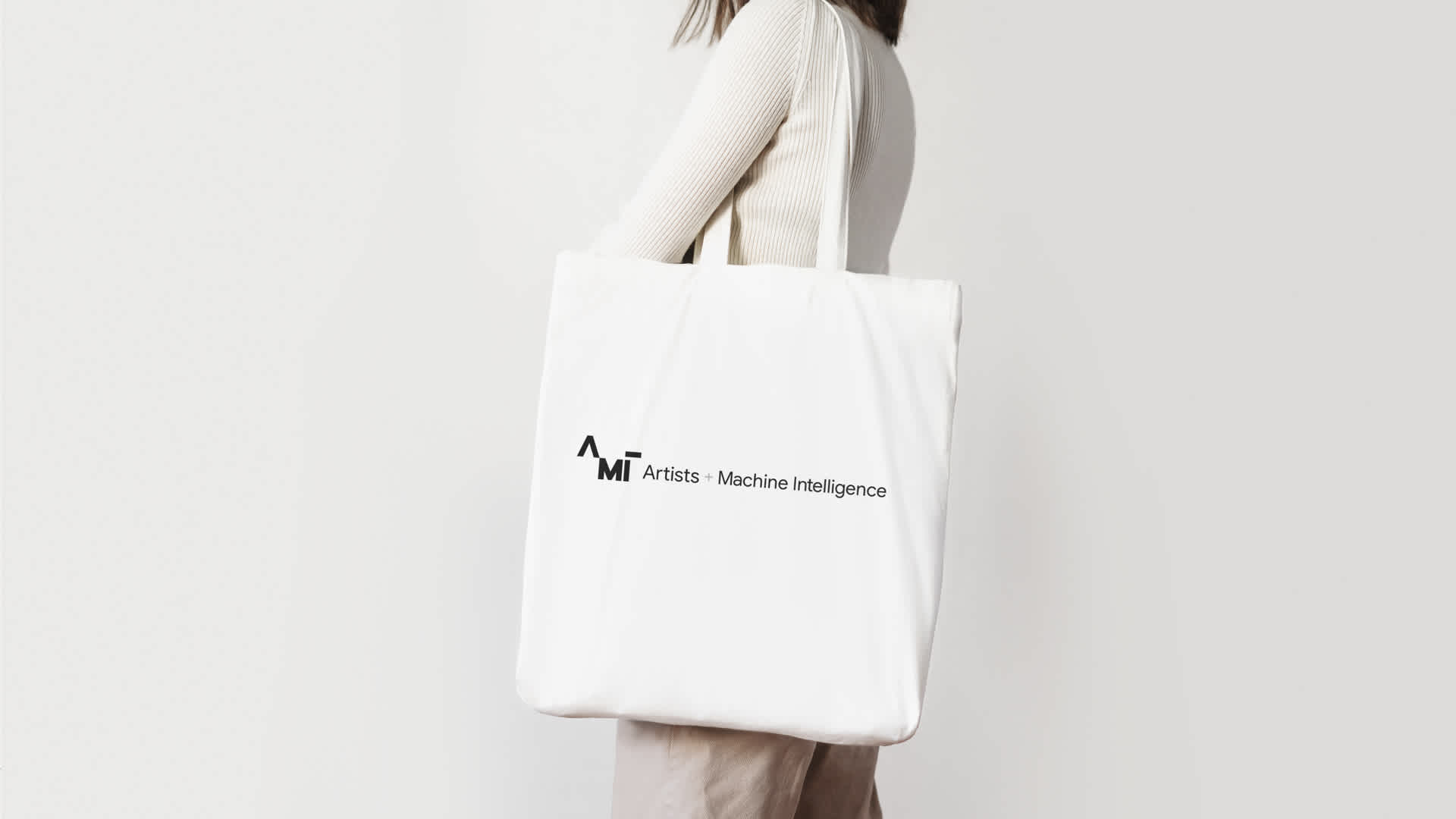 White tote bag with black text.