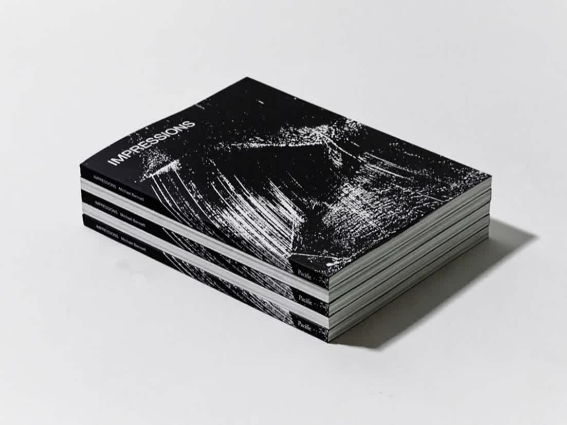 Alternating stack of 5 books. Some spines face outward. The front cover is a black and white abstract artwork.